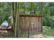 Rustic storage shed with wood siding, offering practical outdoor storage nestled among trees at 3715 Orchard Rd, Columbus, IN 47201