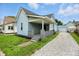Charming home with a covered front porch, light blue siding and gravel driveway at 410 Montgomery St, Shelbyville, IN 46176