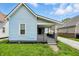 Exterior angle of blue home featuring covered front porch and gray brick foundation at 410 Montgomery St, Shelbyville, IN 46176