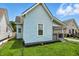 Angle of home showcasing light blue siding, adjacent houses and green foliage at 410 Montgomery St, Shelbyville, IN 46176