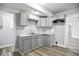 Well-lit kitchen featuring grey cabinetry, stainless sink and modern finishes at 410 Montgomery St, Shelbyville, IN 46176