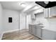 Compact, modern kitchen featuring gray cabinets, bright lighting, and stainless-steel sink at 410 Montgomery St, Shelbyville, IN 46176