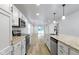 Kitchen featuring granite countertops, white cabinets, an island with seating, and stainless steel appliances at 4129 Cornelius Ave, Indianapolis, IN 46208