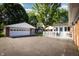 A nice-sized backyard with a garage, basketball court, deck with outdoor seating, and mature trees at 431 N Bauman St, Indianapolis, IN 46214