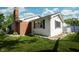 A view of the rear of the home, with a deck, yard, chimney, and mature trees that provide privacy at 431 N Bauman St, Indianapolis, IN 46214
