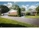 Exterior of a single-story brick home with an asphalt driveway, large lawn, mature trees, and a detached garage at 431 N Bauman St, Indianapolis, IN 46214