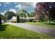 A long asphalt driveway leads to this single-story brick home, with a detached garage, mature trees, and a landscaped lawn at 431 N Bauman St, Indianapolis, IN 46214
