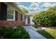 A walkway leads to this single-story home's front entrance, surrounded by garden beds with lush plants and bushes at 431 N Bauman St, Indianapolis, IN 46214