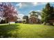 Charming brick home featuring a well-manicured lawn, mature trees, and blue Adirondack chairs at 431 N Bauman St, Indianapolis, IN 46214