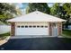 Close-up of the home's detached garage with an automatic door, brick accents, and outdoor lighting at 431 N Bauman St, Indianapolis, IN 46214
