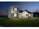 Evening view of a two-story home with brick and vinyl siding, and an illuminated porch at 4330 S 100 E, Lebanon, IN 46052
