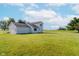 Rear view of a white home featuring an attached garage and large lawn, creating an inviting outdoor space at 4330 S 100 E, Lebanon, IN 46052