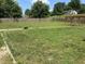 A spacious backyard with lush green grass, a wooden fence, a pergola with a swing set, and a well-maintained lawn at 4466 Buffalo Ln, Martinsville, IN 46151