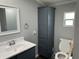 Bathroom with a stylish blue vanity, sink, storage cabinet and toilet at 4466 Buffalo Ln, Martinsville, IN 46151
