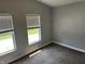 Sunlit bedroom with two windows, neutral walls and trim, and plush carpet flooring at 4466 Buffalo Ln, Martinsville, IN 46151