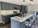 Updated kitchen boasts gray cabinets, stainless appliances, marble countertops, and seating at the island at 4466 Buffalo Ln, Martinsville, IN 46151