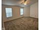 Bright bedroom featuring neutral carpeting, a ceiling fan, and two windows for ample natural light at 4912 Atlanta St, Anderson, IN 46013