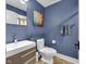 Modern blue bathroom featuring floating vanity, toilet, decorative art and towel rack at 501 Fletcher Ave # A, Indianapolis, IN 46203
