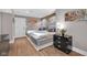 Bedroom with dual beds, laminate flooring, stone accent wall, and modern lighting at 501 Fletcher Ave # A, Indianapolis, IN 46203
