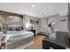 Bedroom with a stone accent wall, laminate flooring, and exercise equipment at 501 Fletcher Ave # A, Indianapolis, IN 46203
