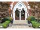 Elegant entryway with brick archway, double doors, address number, and manicured landscaping at 501 Fletcher Ave # A, Indianapolis, IN 46203