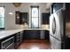 Well-lit kitchen with dark wood cabinets, stainless steel appliances, and hardwood floors at 501 Fletcher Ave # A, Indianapolis, IN 46203