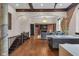 Open-concept living room features hardwood floors, exposed brick, fireplace, and wood beam ceiling at 501 Fletcher Ave # A, Indianapolis, IN 46203