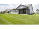 Rear view of a gray single-Gathering home with a covered patio and spacious manicured lawn at 5081 Holborn Ave, McCordsville, IN 46055