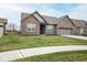 Charming brick home featuring an attached two-car garage, green lawn, and sparse landscaping at 5081 Holborn Ave, McCordsville, IN 46055