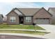 Charming brick home featuring an attached two-car garage and manicured front lawn at 5081 Holborn Ave, McCordsville, IN 46055