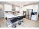 Bright kitchen features an island with bar seating, stainless steel appliances, and white cabinets at 5081 Holborn Ave, McCordsville, IN 46055