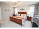 This bedroom includes decorative curtains, carpet, neutral walls, and a view of a treadmill at 5081 Holborn Ave, McCordsville, IN 46055