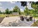 Open backyard with concrete patio, comfortable outdoor furniture and large trees at 5226 W Southport Rd, Indianapolis, IN 46221