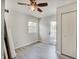 Bright bedroom with wood-look floors, closet, a ceiling fan, and a glass door at 5226 W Southport Rd, Indianapolis, IN 46221