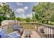 Outdoor wooden deck with chairs, table, black railings, and a grill at 5226 W Southport Rd, Indianapolis, IN 46221