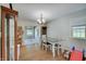 Bright dining room with hardwood floors, neutral walls, and a view of the enclosed patio at 5226 W Southport Rd, Indianapolis, IN 46221