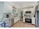 Stylish kitchen with white cabinetry, stainless steel appliances, and light wood flooring at 5226 W Southport Rd, Indianapolis, IN 46221