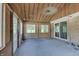 Sunroom with brick and paneled walls, multiple windows, and wood plank ceiling at 5226 W Southport Rd, Indianapolis, IN 46221