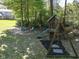 A charming backyard featuring a playset, a slide, and a cozy firepit surrounded by colorful Adirondack chairs at 5826 Winding Way Ln, Indianapolis, IN 46220