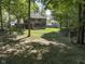 Expansive backyard with mature trees, a large lawn, a playset, and a patio, offering ample space for outdoor activities at 5826 Winding Way Ln, Indianapolis, IN 46220