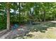 Well manicured backyard featuring mature trees, playground, and seating at 5826 Winding Way Ln, Indianapolis, IN 46220
