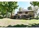Back exterior showcasing a brick home, patio, and well-maintained lawn at 5826 Winding Way Ln, Indianapolis, IN 46220