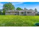 Spacious backyard showcasing well-maintained lawn, screened in porch, and mature trees at 5850 E 54Th Pl, Indianapolis, IN 46226