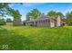 Lush backyard featuring a large lawn, screened-in porch, and mature trees at 5850 E 54Th Pl, Indianapolis, IN 46226