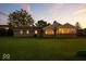 Well-maintained backyard with a large lawn, mature trees, and screened-in porch at 5850 E 54Th Pl, Indianapolis, IN 46226