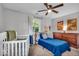 Cozy bedroom with a crib, blue bed, and plenty of natural light at 5850 E 54Th Pl, Indianapolis, IN 46226