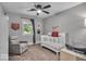 Comfortable bedroom featuring a glider chair, crib, and a ceiling fan at 5850 E 54Th Pl, Indianapolis, IN 46226