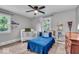A cheerful bedroom featuring a blue bed and decor, two large windows and a ceiling fan at 5850 E 54Th Pl, Indianapolis, IN 46226