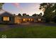 Evening shot of ranch home with brick accents and warm interior lights at 5850 E 54Th Pl, Indianapolis, IN 46226