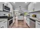 Modern kitchen with stainless steel appliances and white cabinetry, leading into an open-concept living space at 5850 E 54Th Pl, Indianapolis, IN 46226